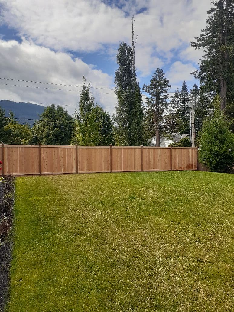Cedar privacy fence installation with landscaped lawn in Seattle